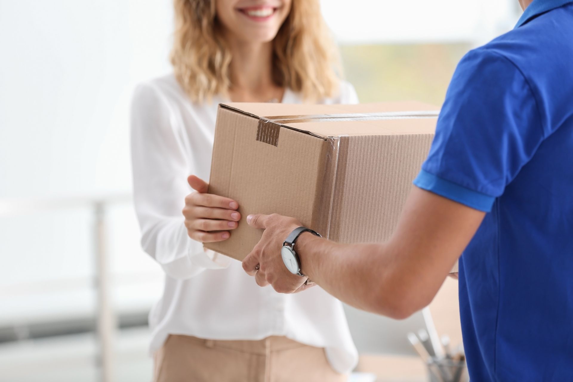 A happy woman is receiving a parcel from a courier, showcasing a reliable courier delivery service. A happy woman is receiving a parcel from a courier, showcasing a reliable courier delivery service.
