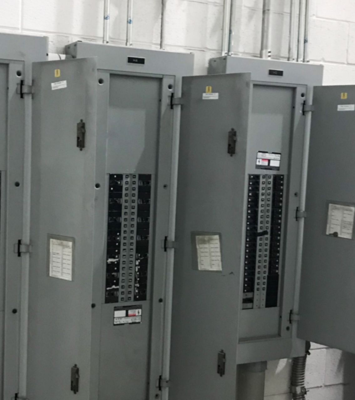Three commercial breaker panel boxes installed on CMU block wall in Roswell Georgia