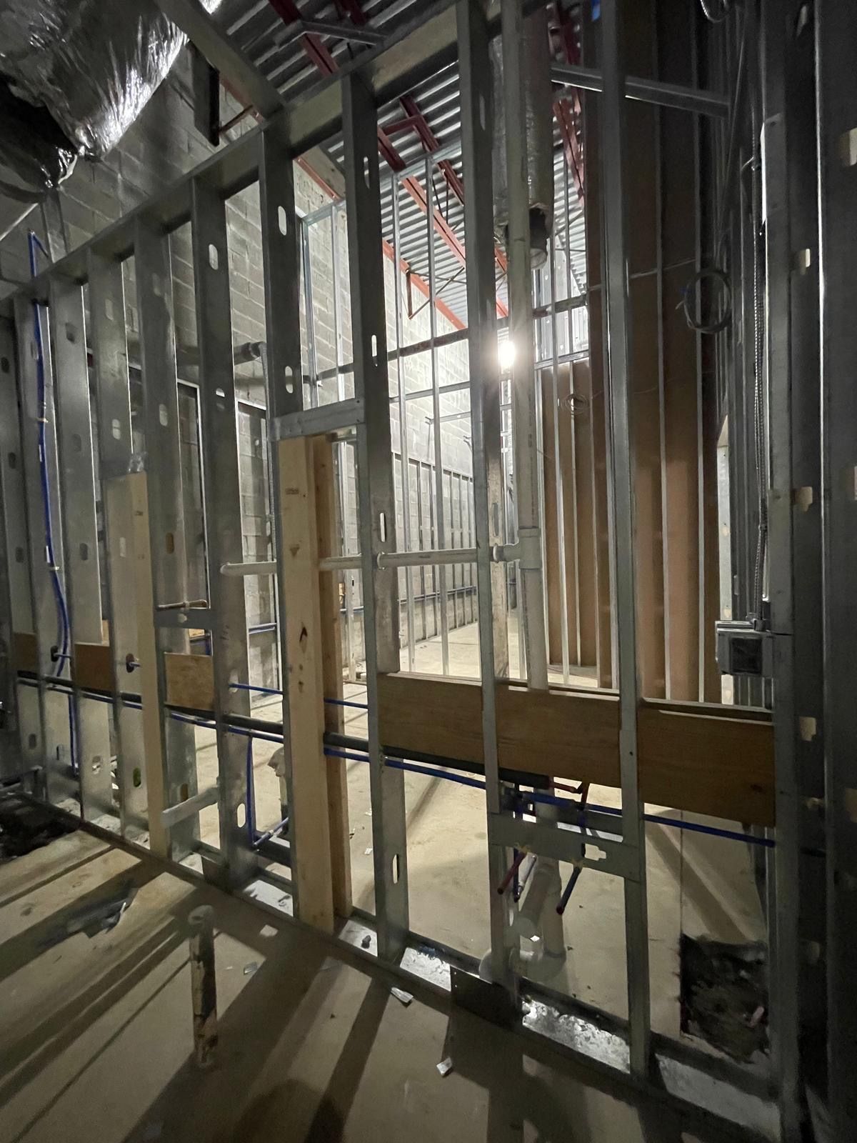 Commercial interior steel stud framing with plumbing rough-in during build-out in Woodstock Georgia