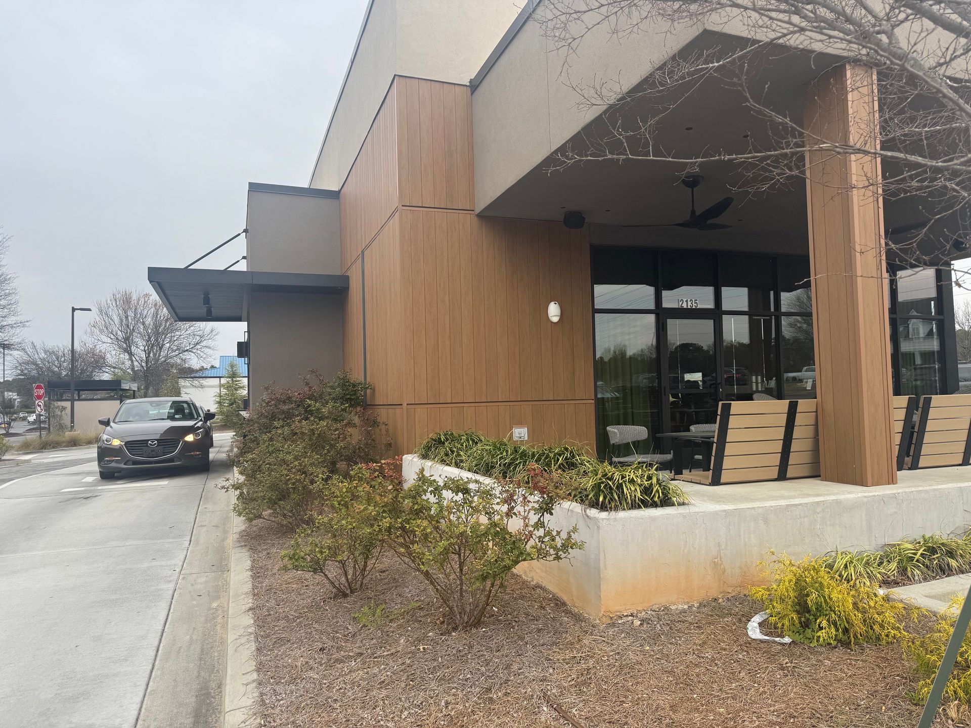 Completed commercial restaurant exterior with wood panel siding, modern canopy, and outdoor patio seating in Marietta Georgia