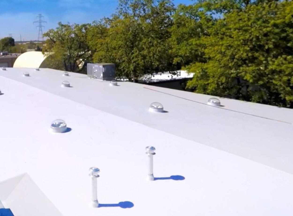Completed commercial TPO white flat roof with dome skylights and HVAC unit in Roswell Georgia