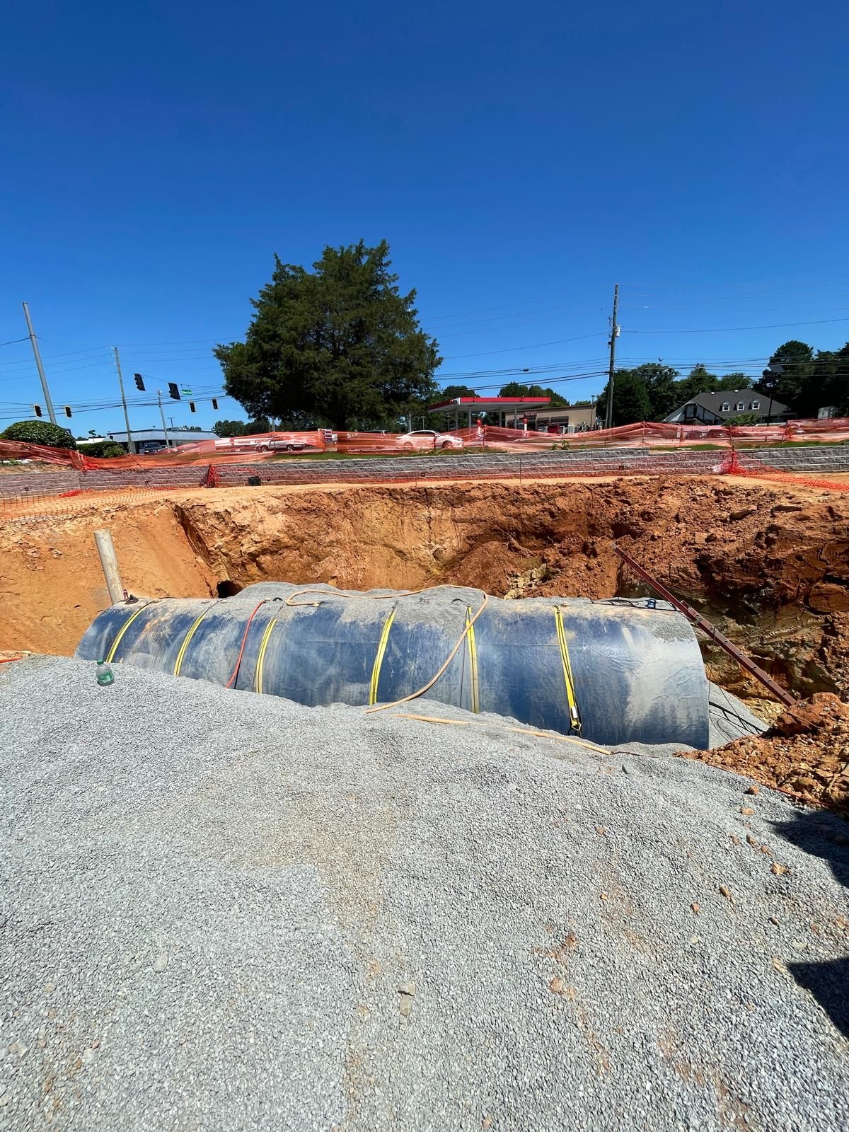 Large underground storage tank being installed in excavated commercial construction site in Roswell Georgia