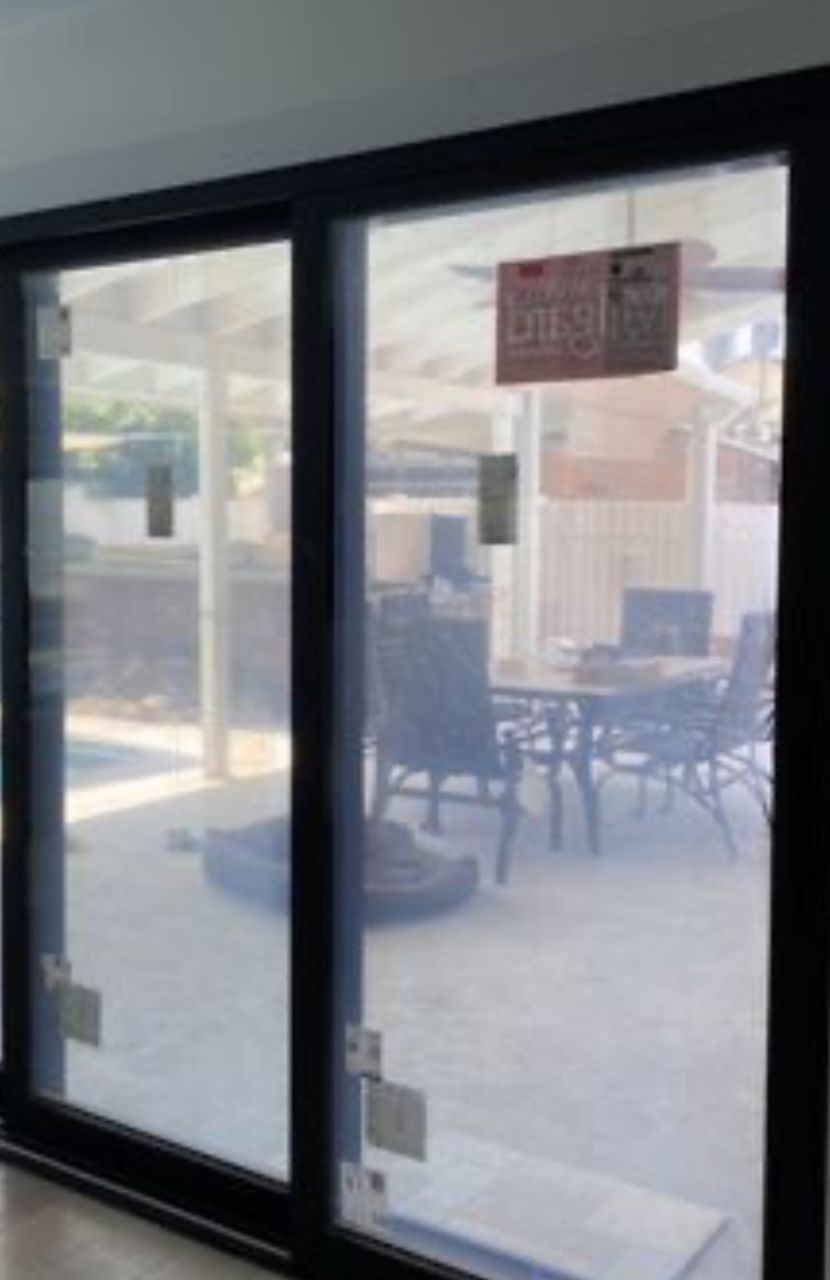 Interior view of impact glass sliding doors opening to covered patio and pool area in luxury home in Woodstock Georgia