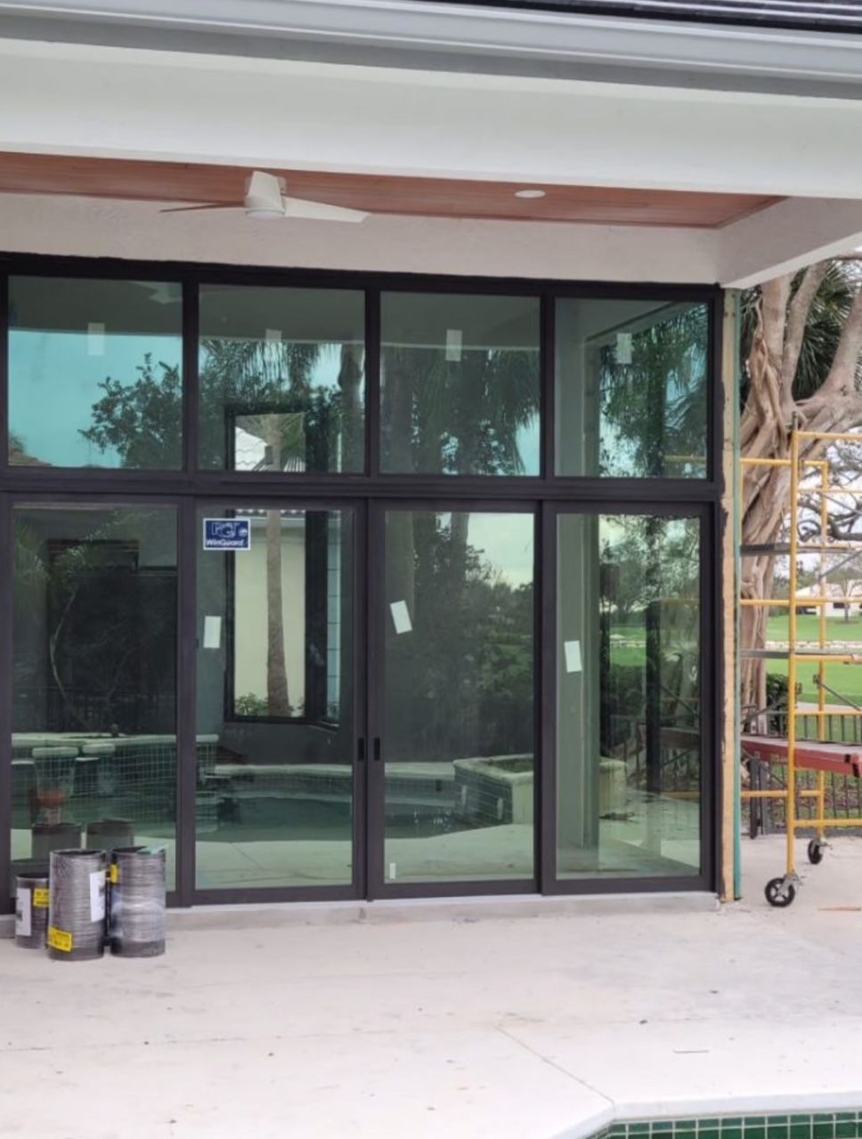 Luxury home with floor-to-ceiling impact glass sliding door system and pool deck during construction in Marietta Georgia
