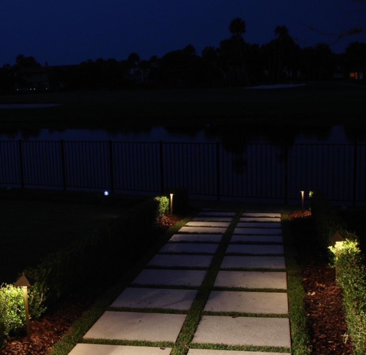 Outdoor landscape pathway with bollard lighting and stepping stones at night in Marietta Georgia