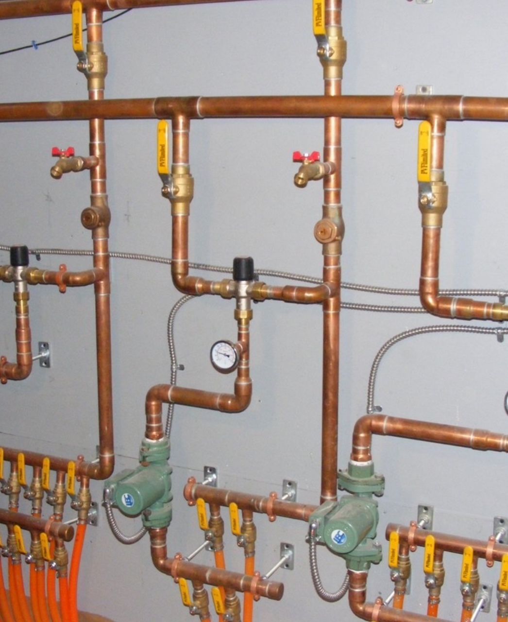 Radiant heat hydronic plumbing system with copper manifold, brass valves, and circulator pumps in Roswell Georgia
