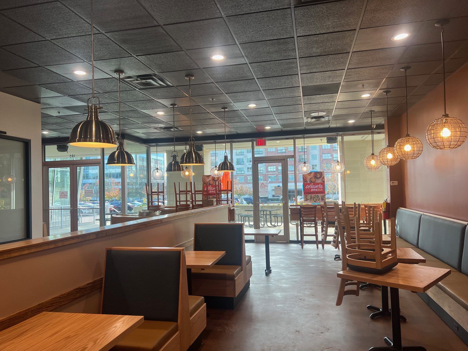 Restaurant dining room with pendant lighting, booth seating, and bar counter in Woodstock, Georgia
