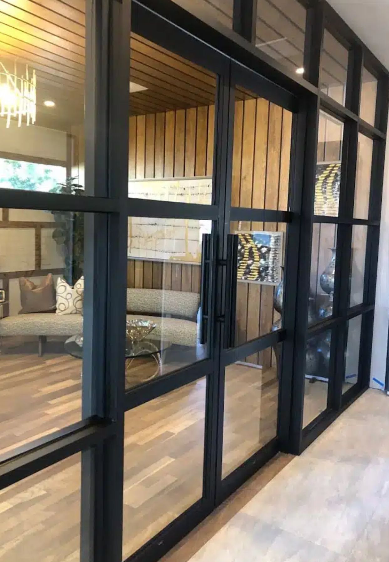 Custom black steel frame glass partition wall installation in luxury residential or commercial space with wood slat ceiling by contractor serving Marietta GA