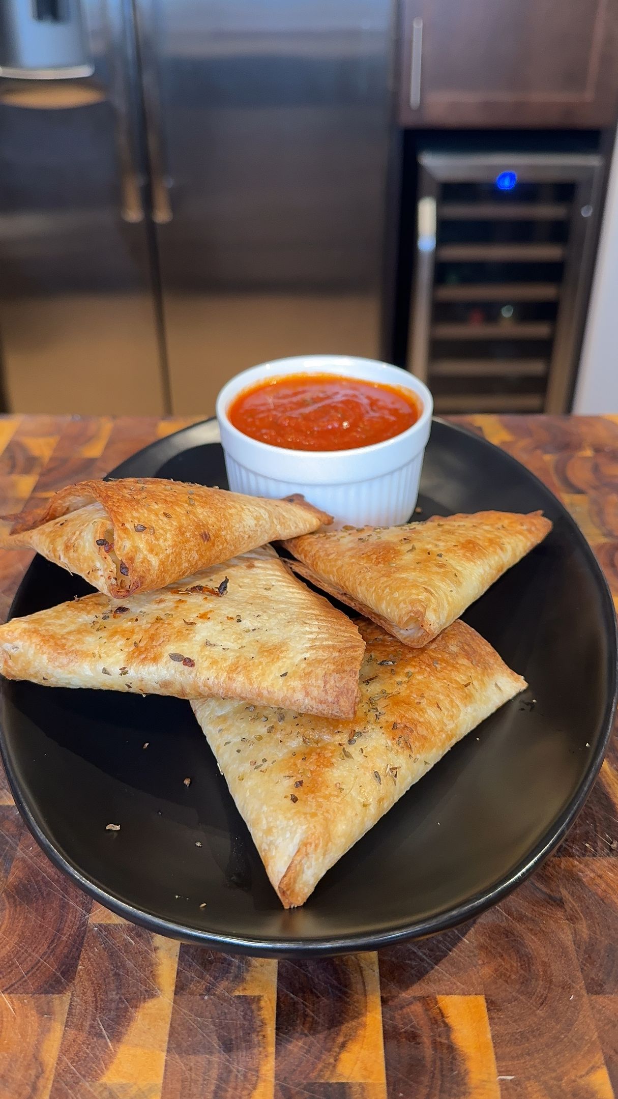 Crispy filled triangles on a plate with marinara sauce.