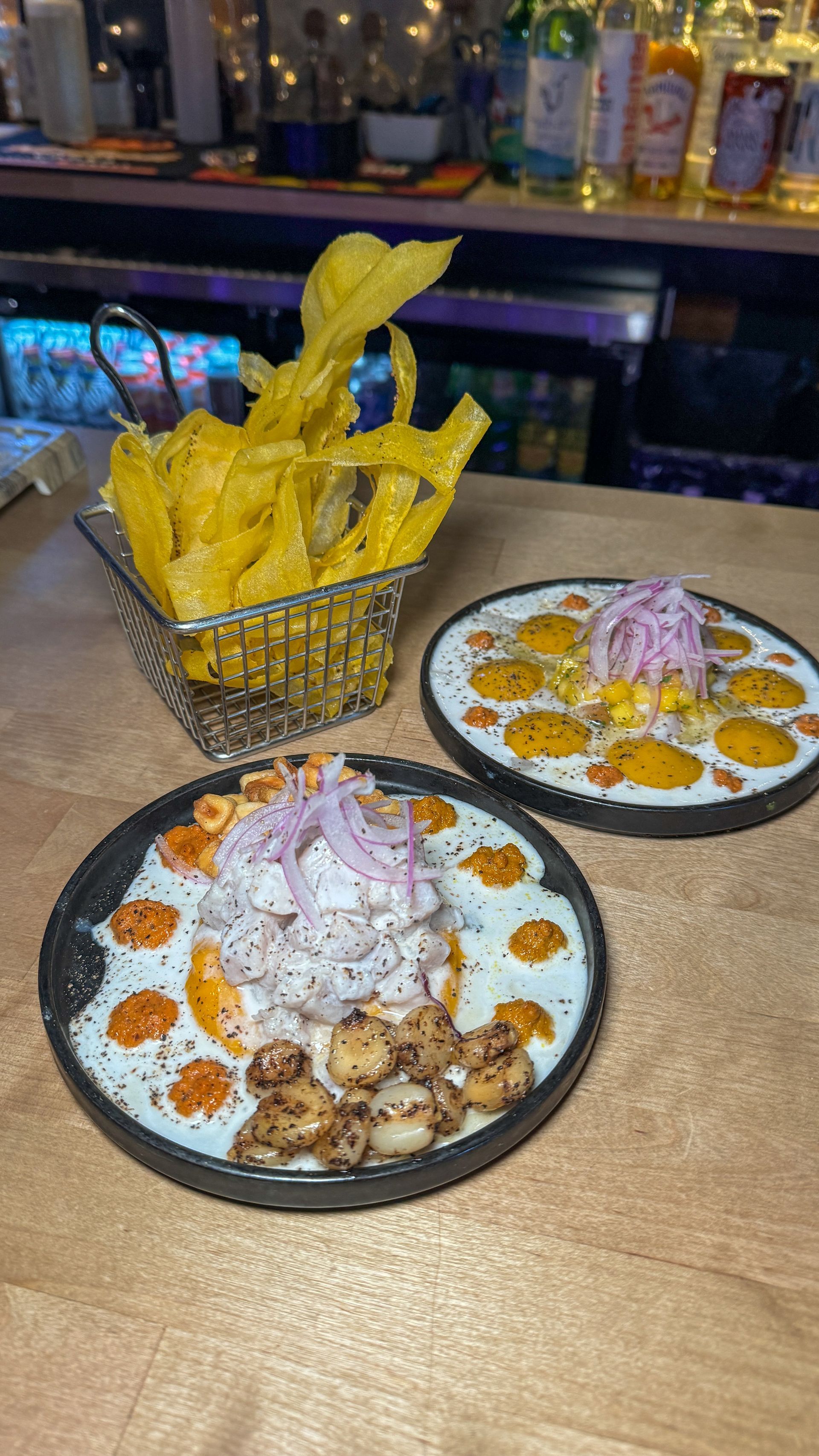 Two plates of food are sitting on a wooden table.
