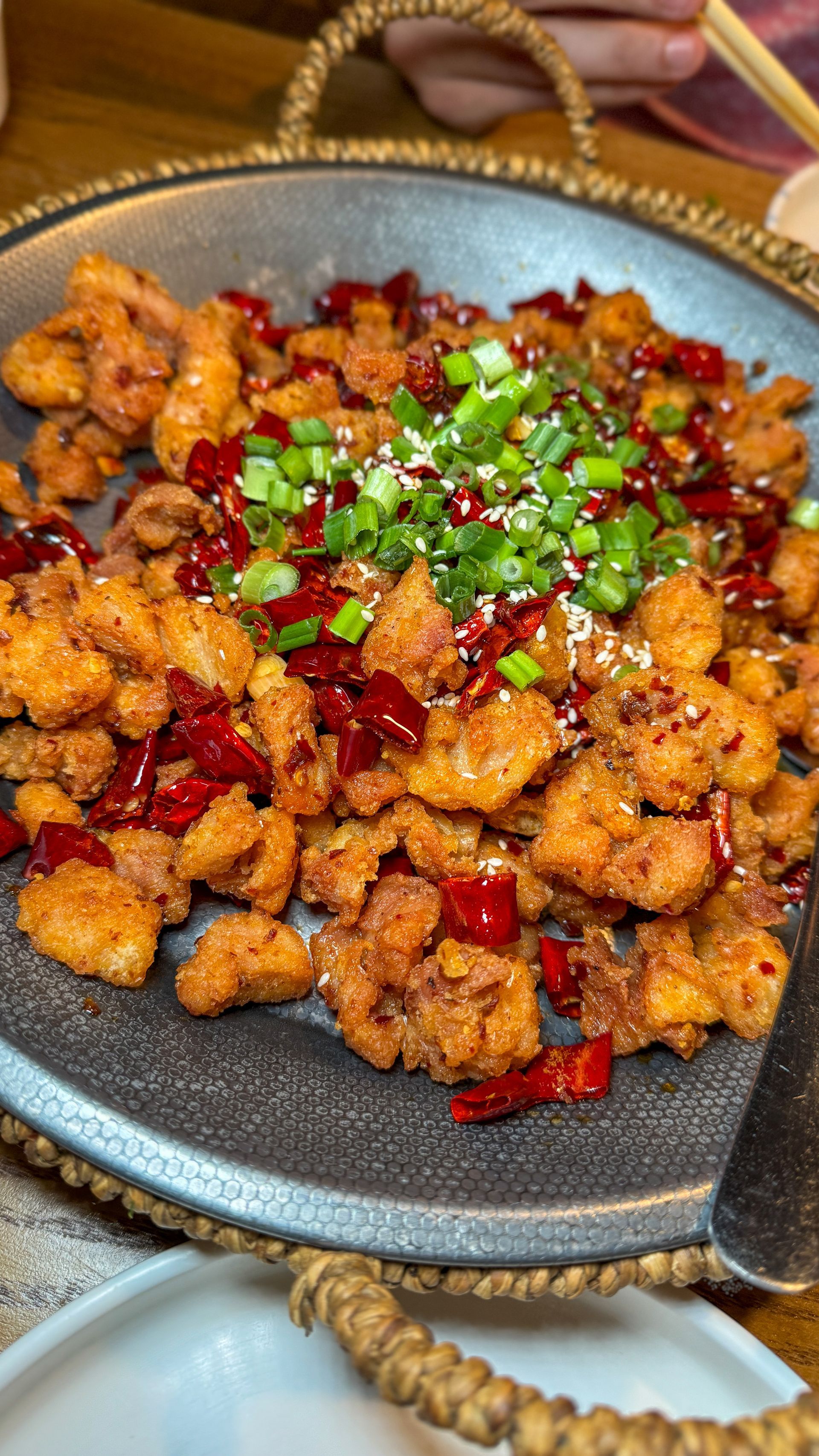 A close up of a plate of food with chopsticks on a table.