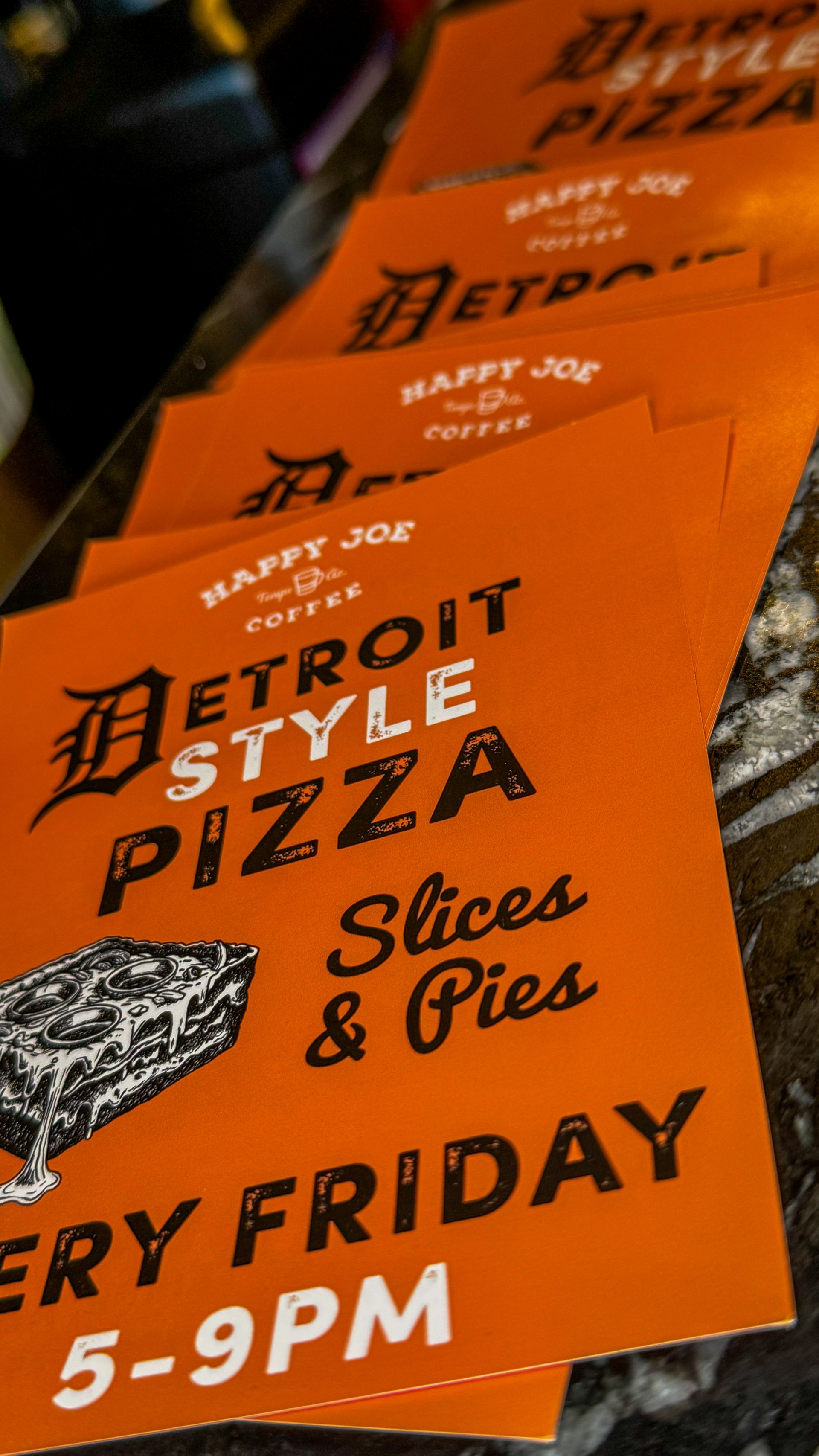 Orange flyers for Detroit Style Pizza. Features text and a pizza illustration, and says delivery every Friday 5-9PM.