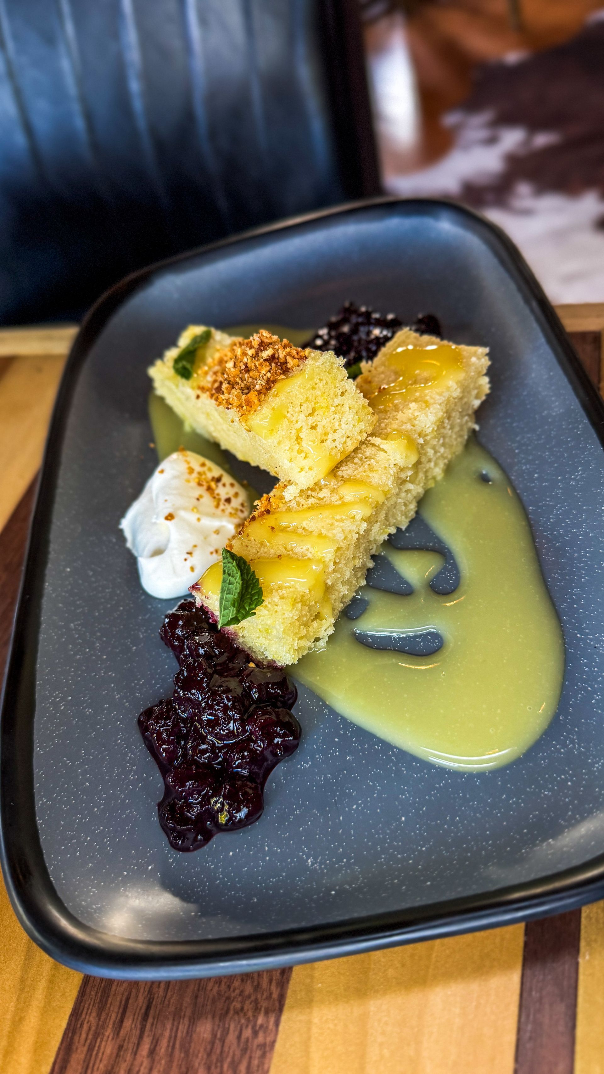 Dessert plate with golden rolled pastries, dark berry sauce, and pale green custard