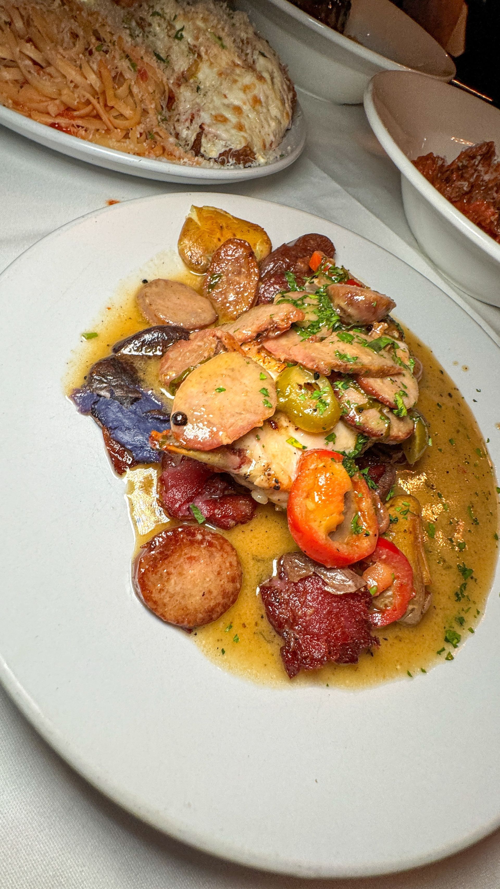 A white plate topped with meat and vegetables on a table.