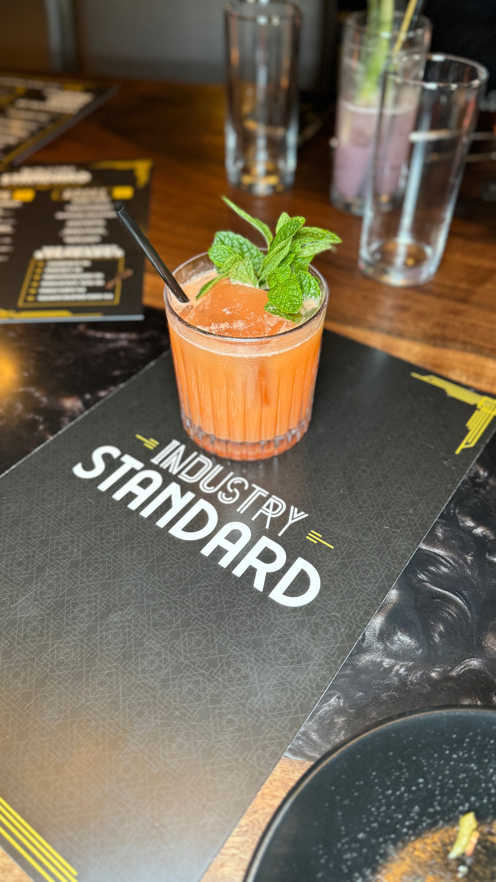 A drink is sitting on a table next to a menu.