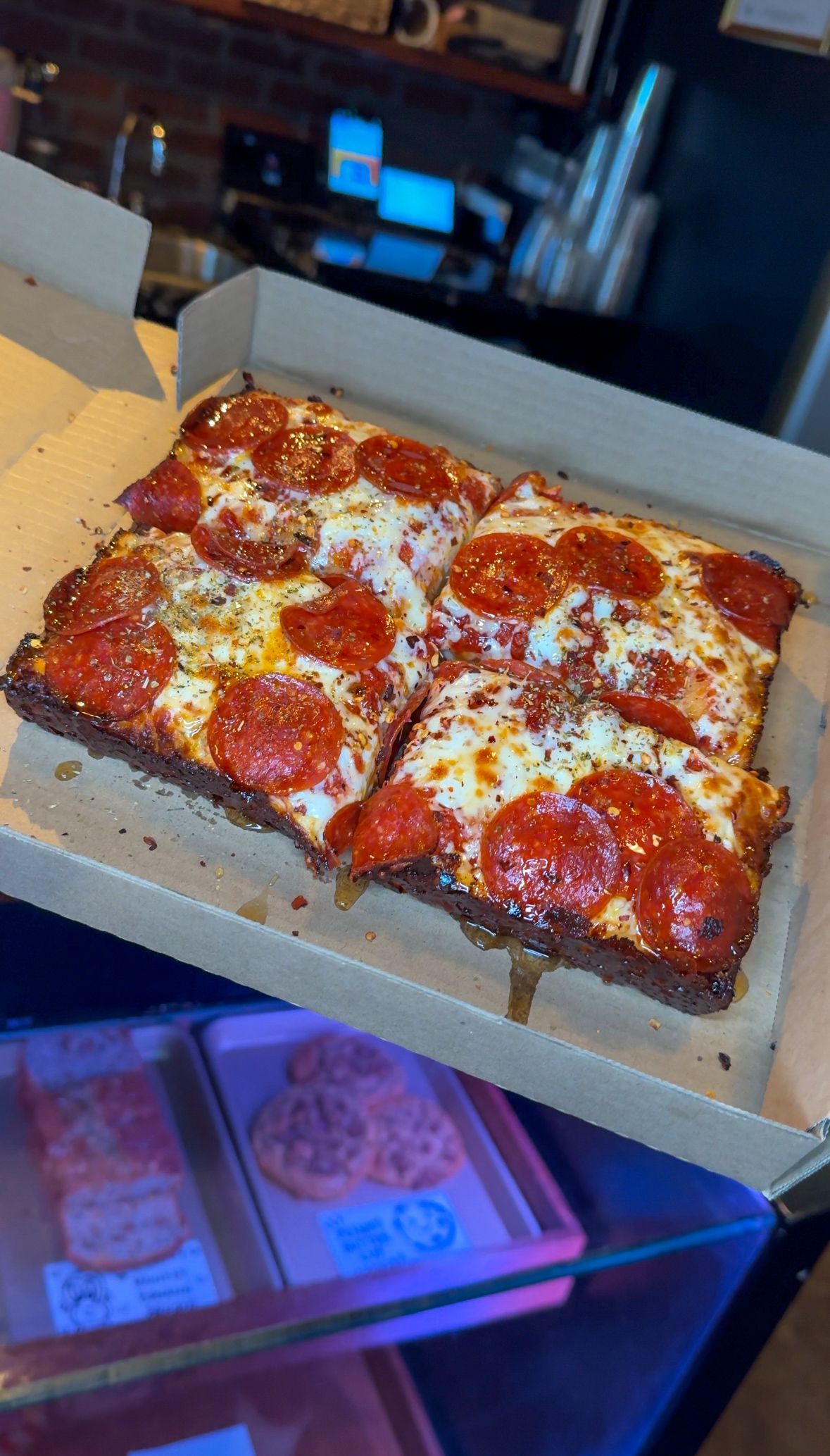 Pepperoni pizza slices in a cardboard box, close-up. Cheese and pepperoni toppings, crust looks crispy.