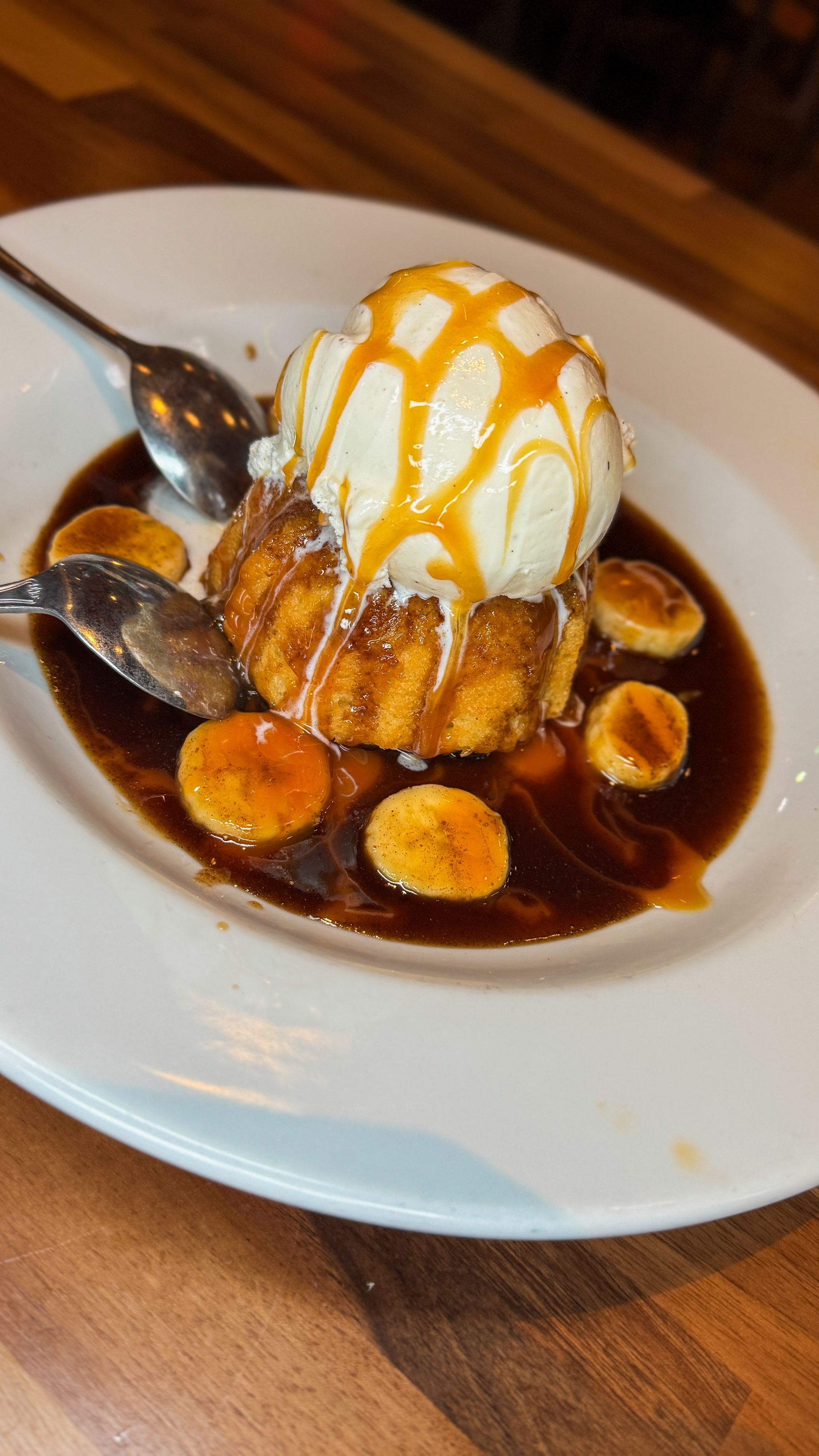 Dessert plate: banana bread pudding with ice cream, caramel sauce, and caramelized bananas.
