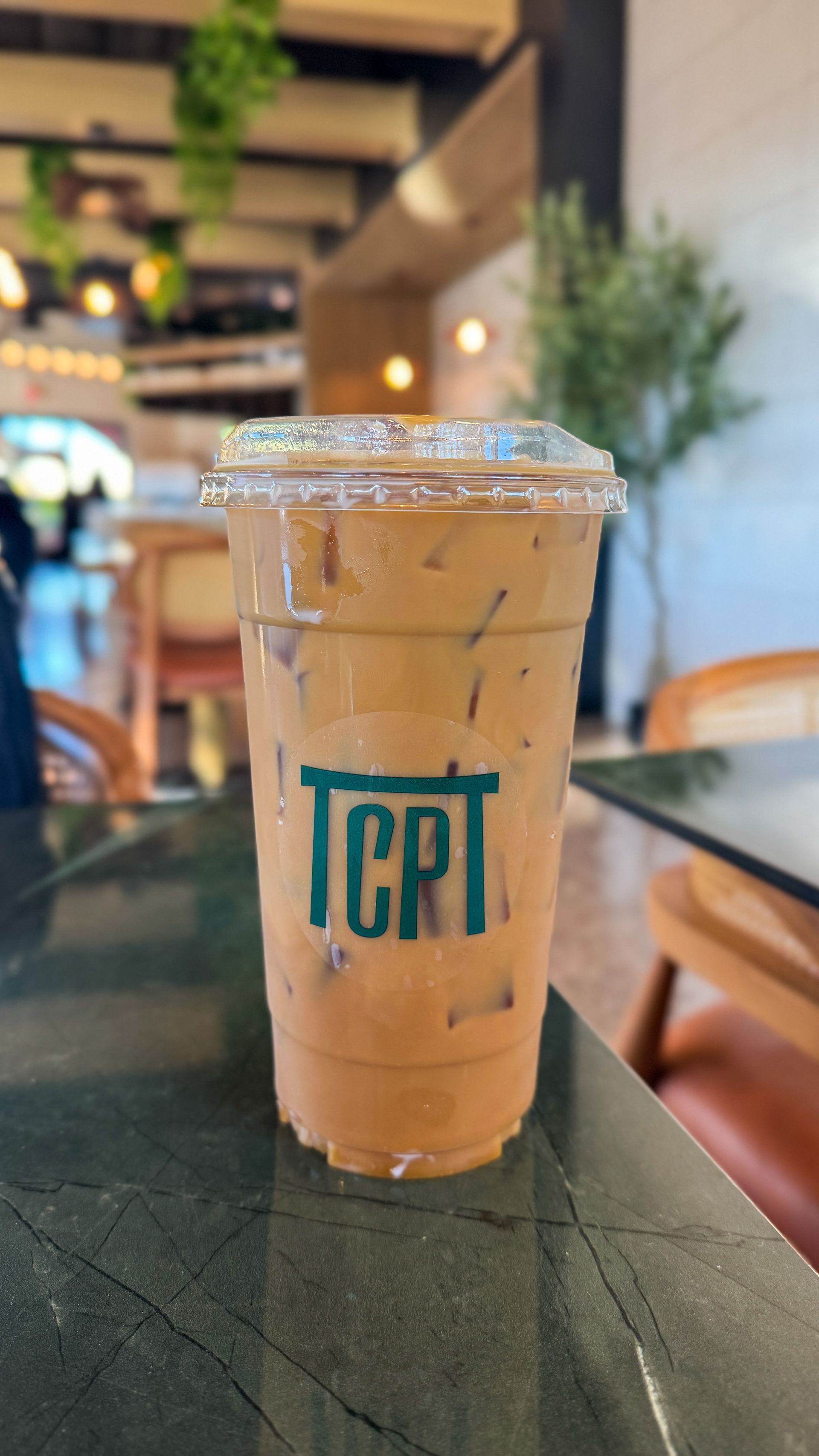 Iced coffee drink in a clear plastic cup with the logo 