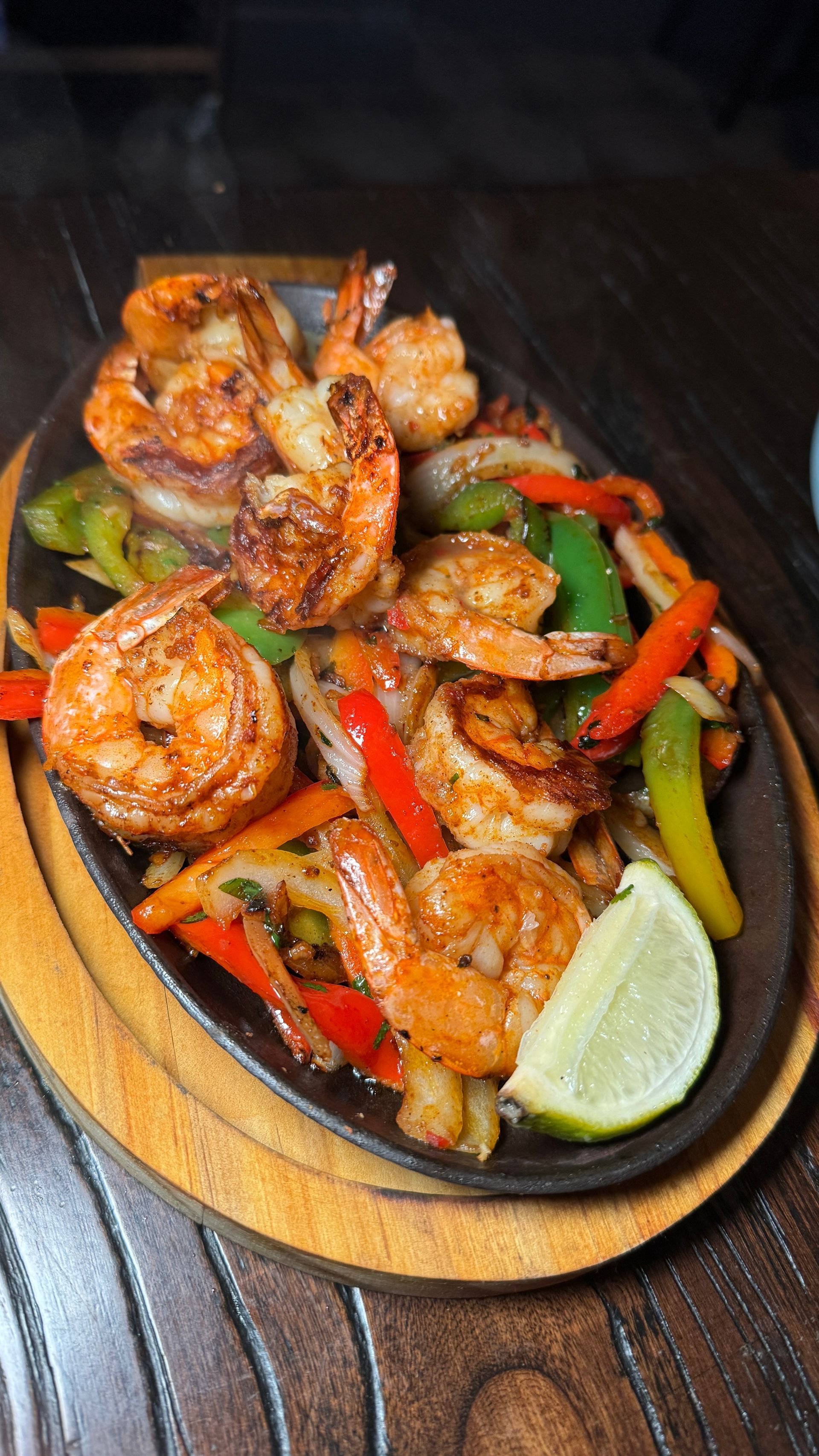 A plate of shrimp and vegetables on a wooden table.