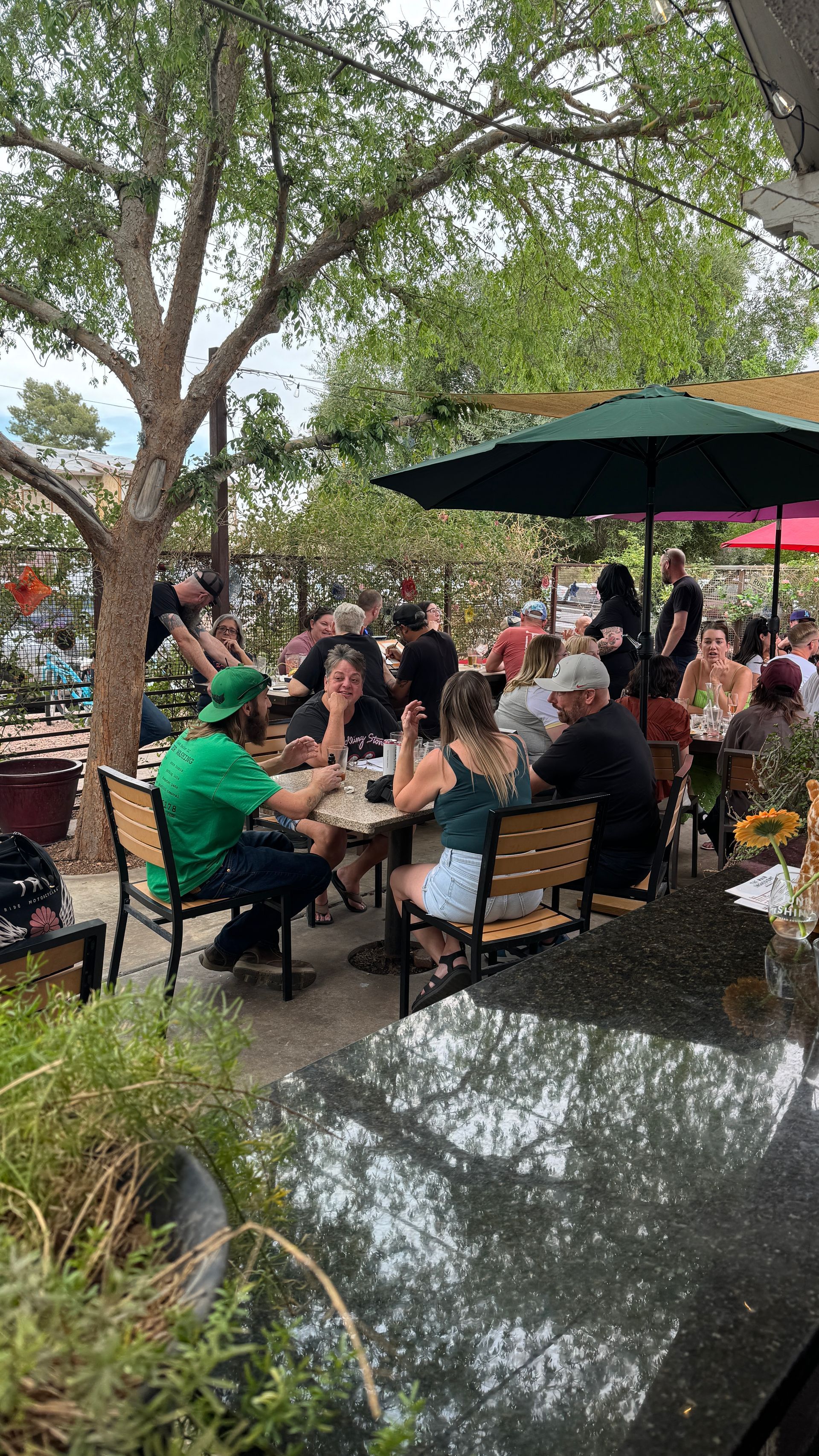 A group of people are sitting at tables under umbrellas in a restaurant.