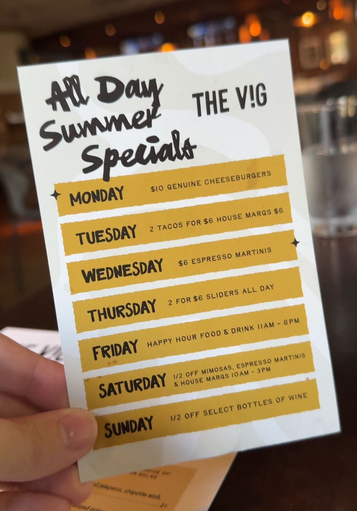A person is holding a menu that says all day summer specials