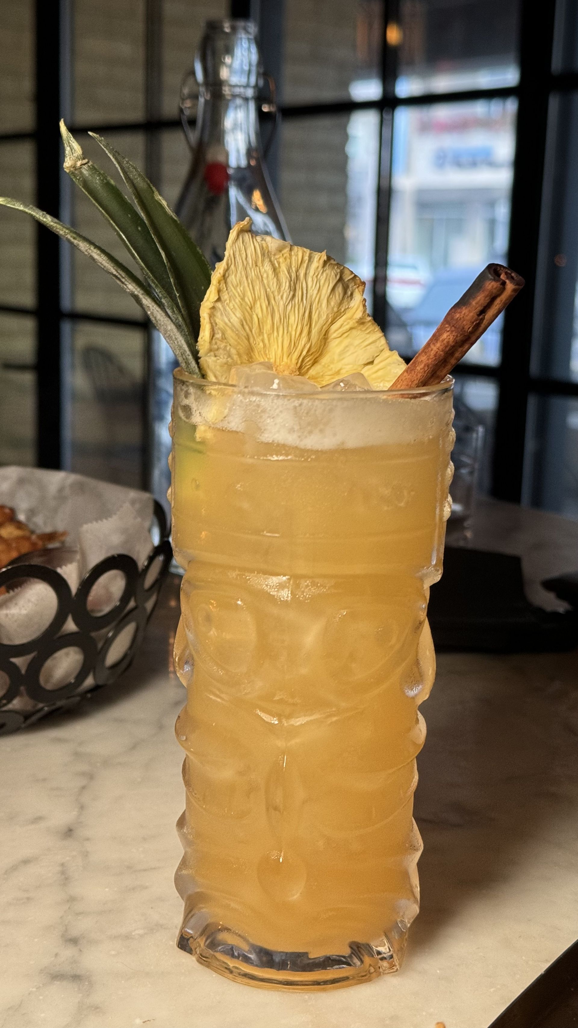 The Beverly - A close up of a drink in a tiki glass on a table.