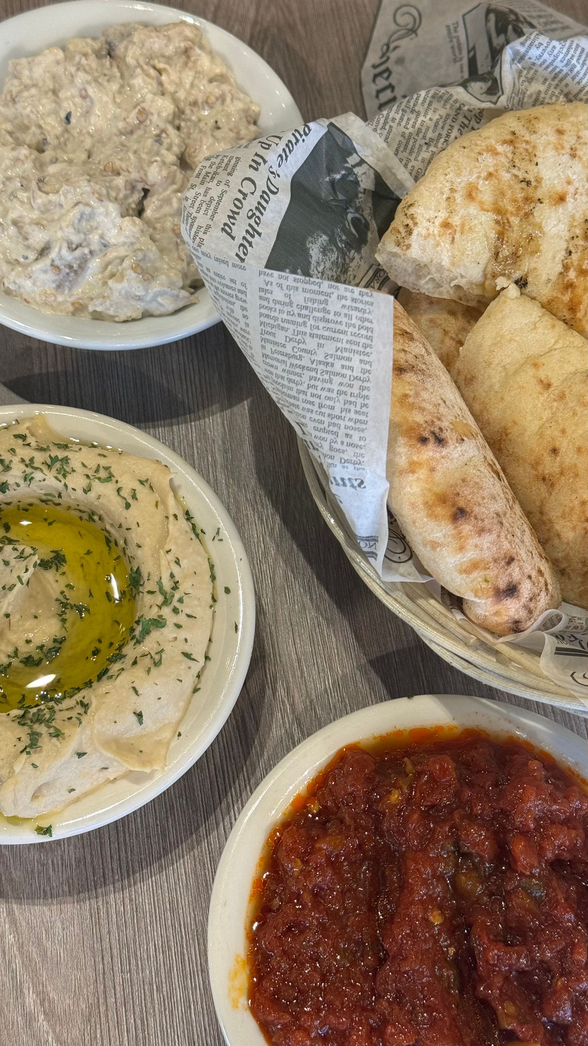 Fata Morgana - A table topped with bowls of food and a basket of bread.