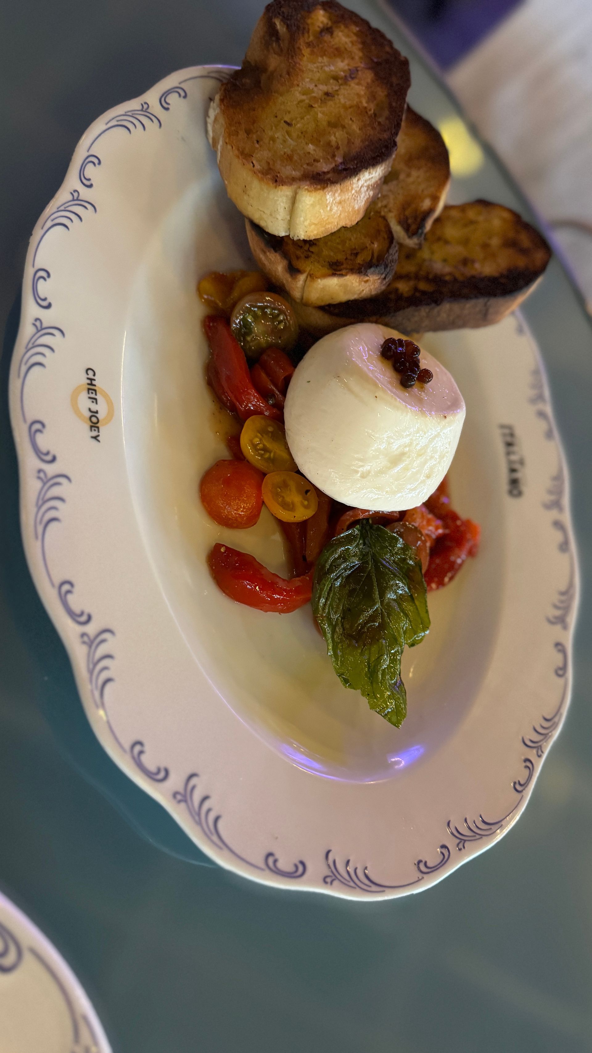 A white plate topped with a sandwich and vegetables on a table.