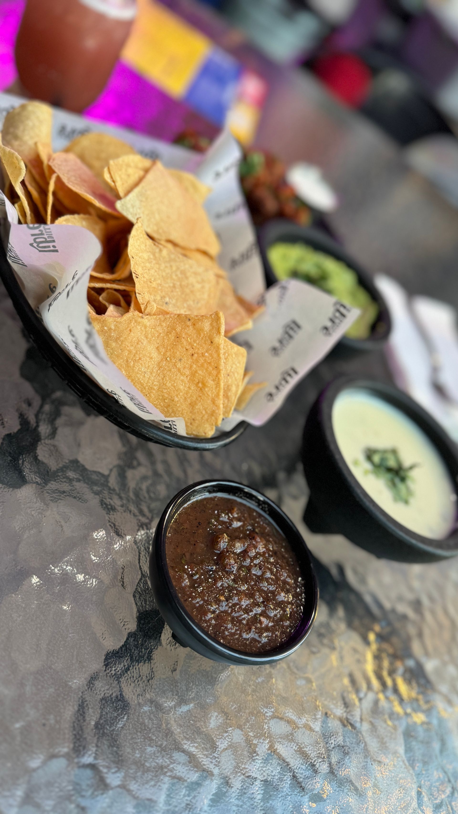 A bowl of tortilla chips and a bowl of salsa on a table.