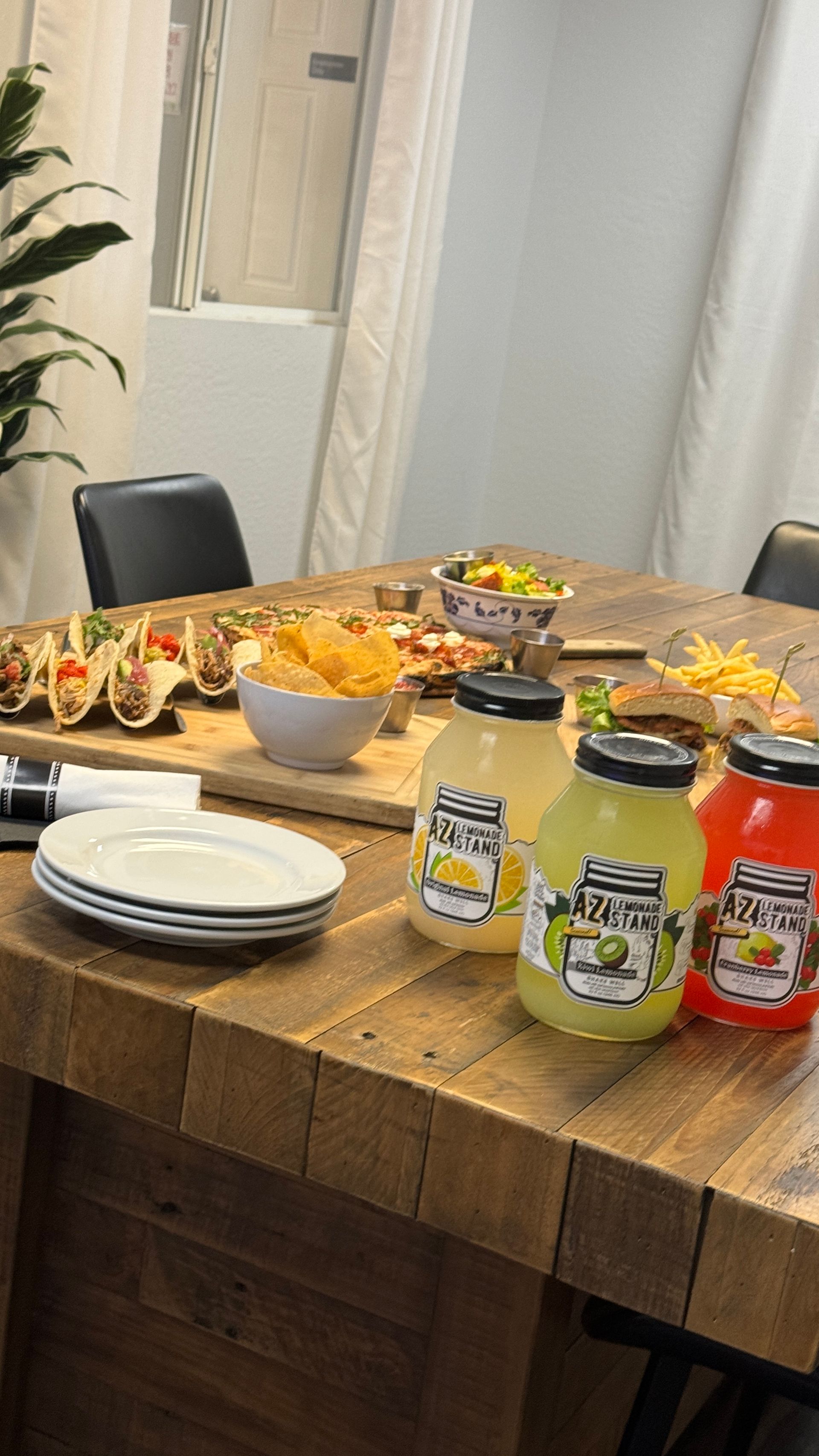A wooden table topped with a variety of food and drinks.