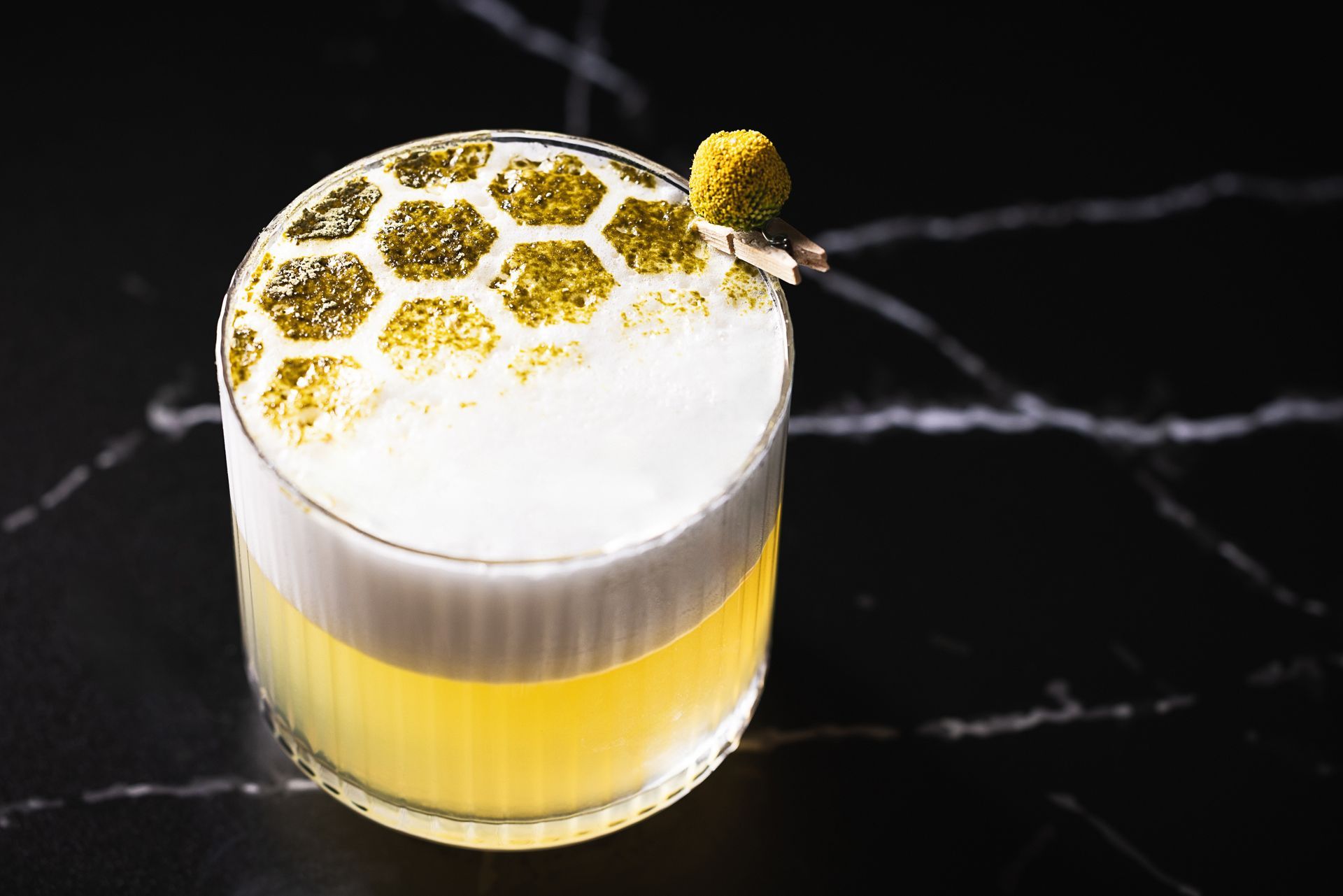 A close up of a drink in a glass on a table.
