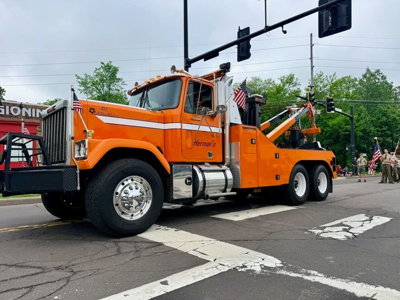 Orange tow truck on a city street at an intersection