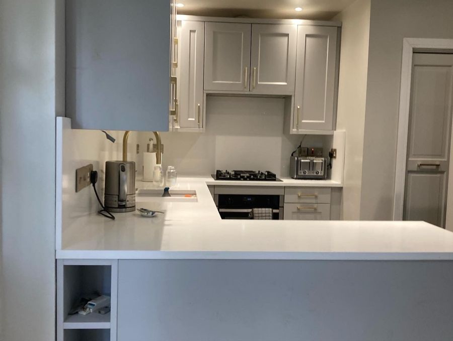 Compact kitchen refit with integrated hob and warm lighting