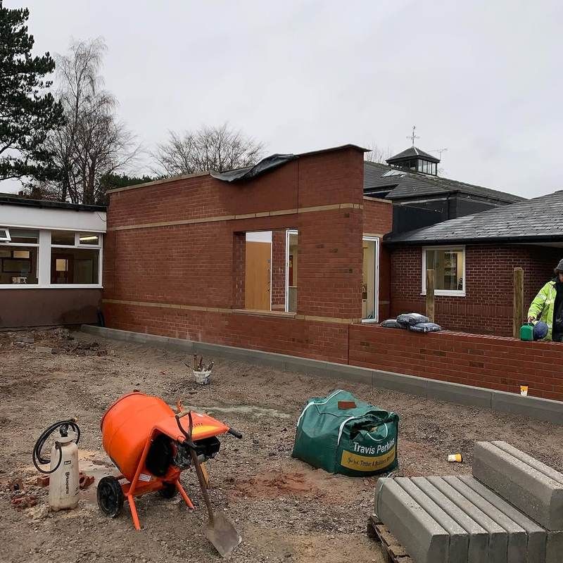 Nursery extension brickwork nearing completion, with matching brick boundary wall