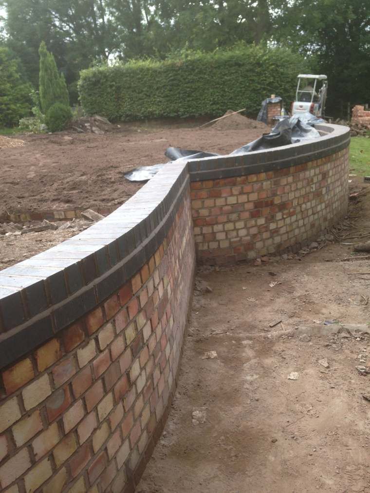 Curved brick retaining wall being built
