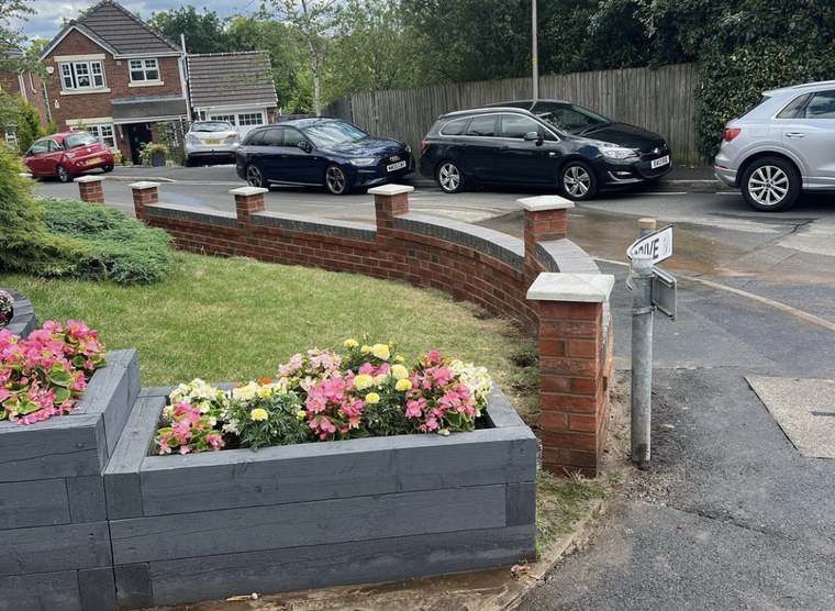 Finished curved brick boundary wall along a driveway