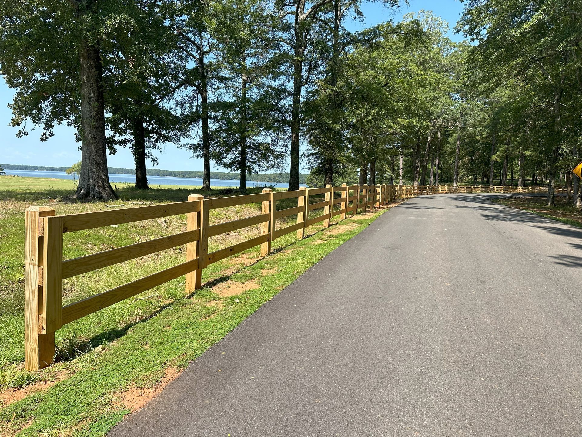 A wooden fence along the side of a road.