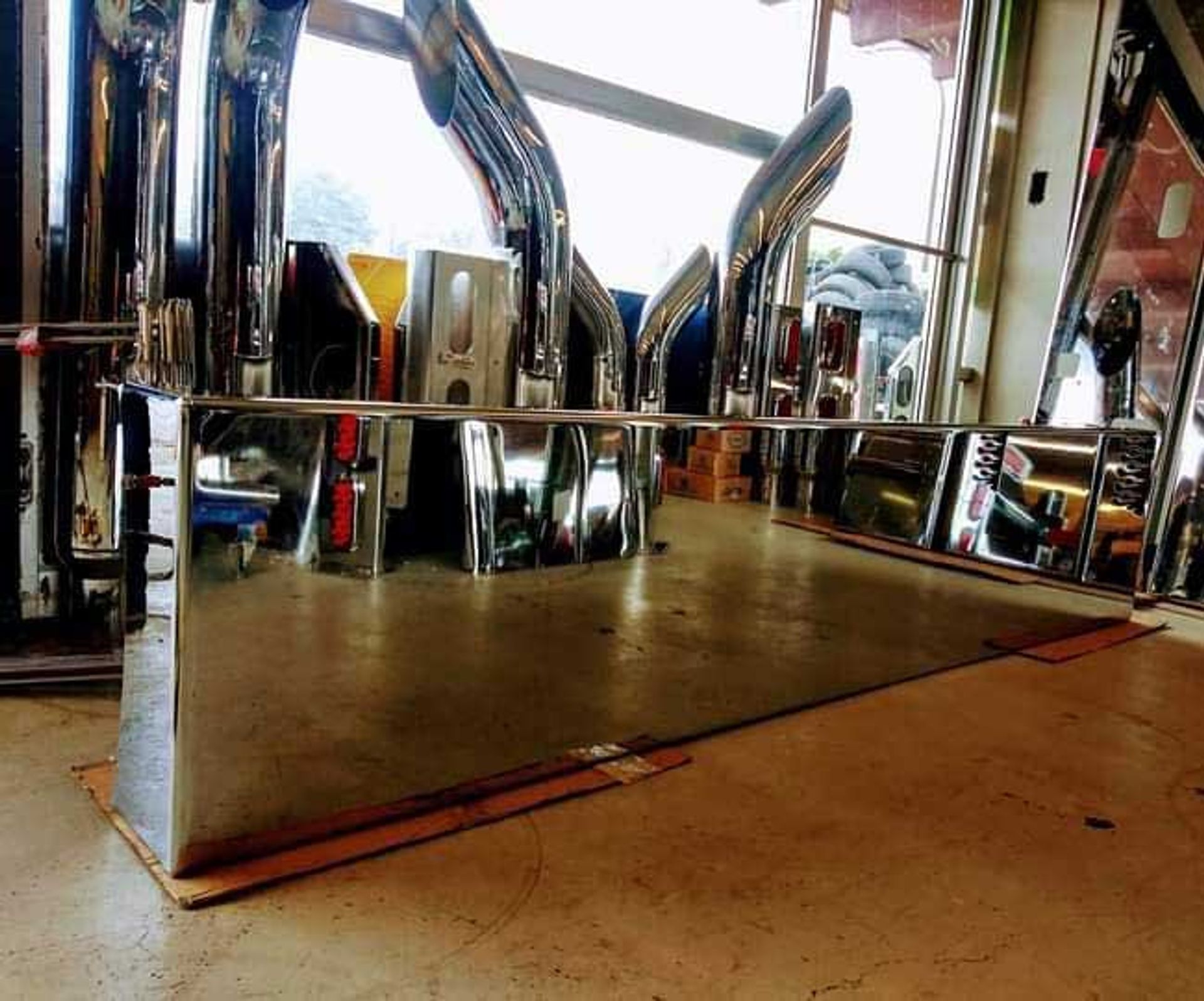 A row of stainless steel pipes are lined up in a room.