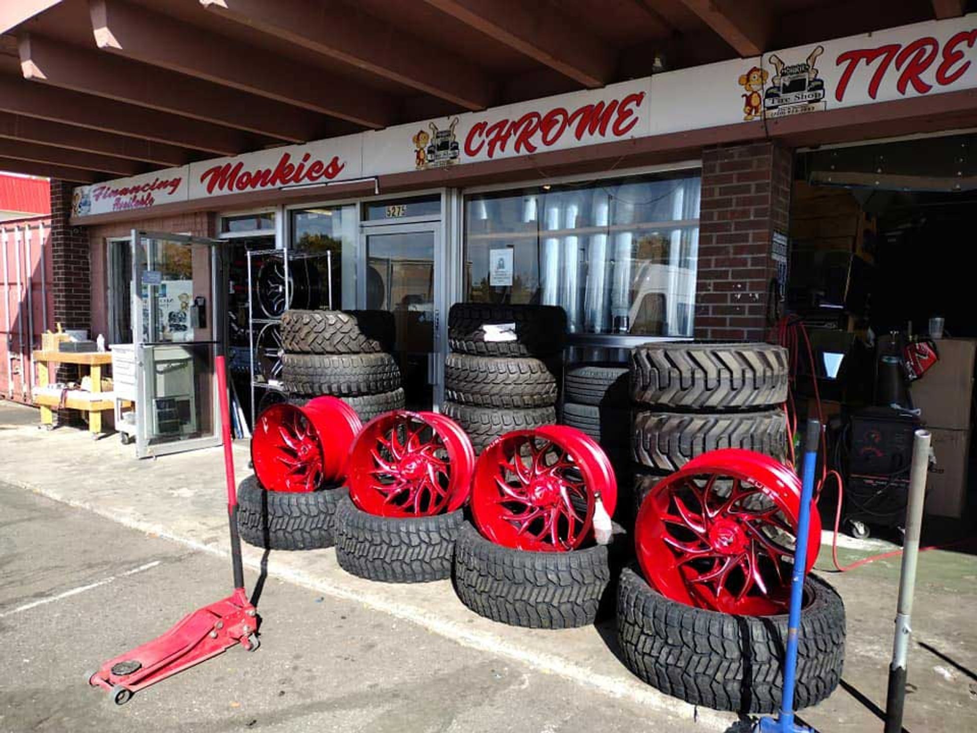 A tire shop with red wheels and tires in front of it