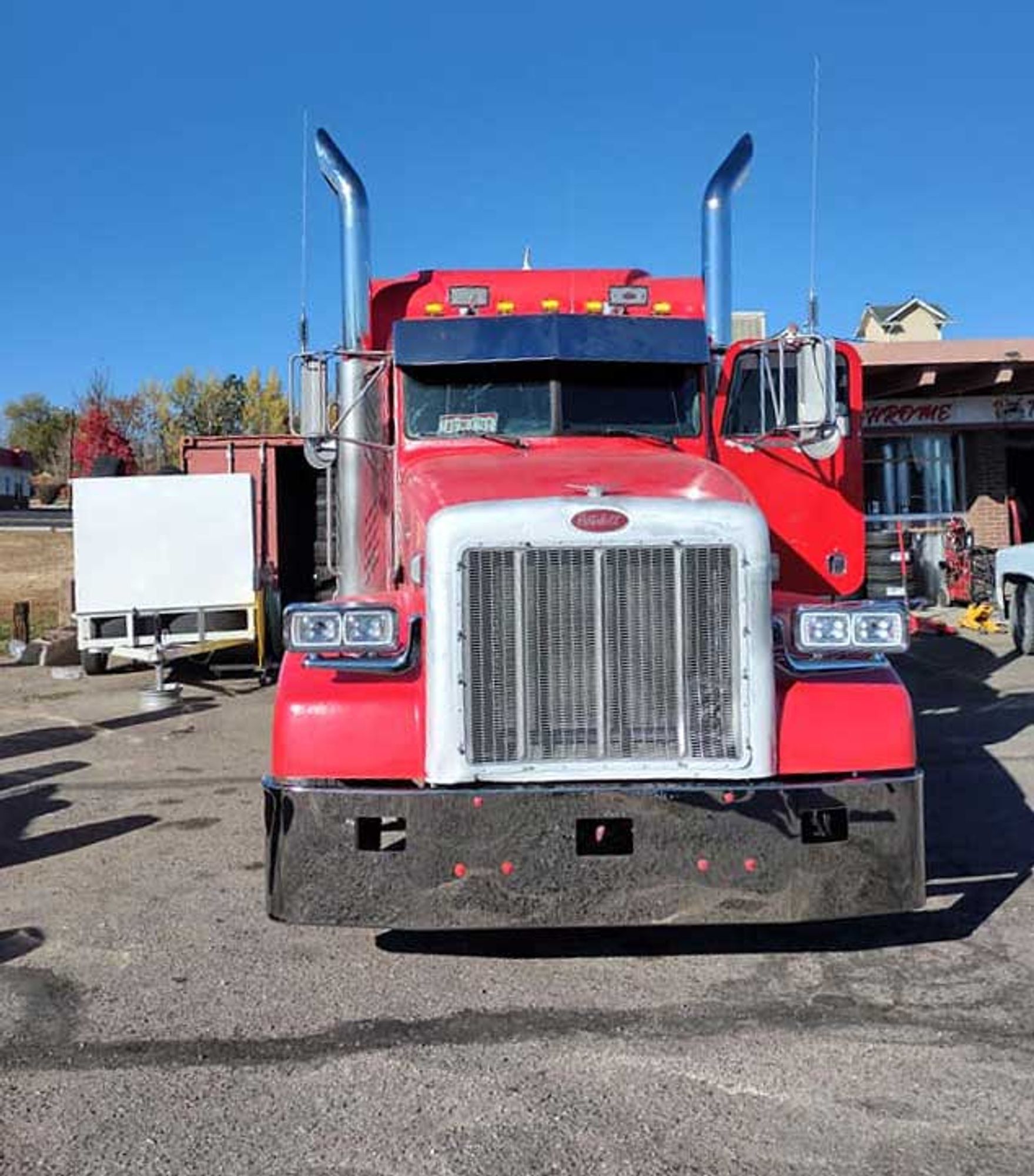 A red semi truck is parked in a parking lot