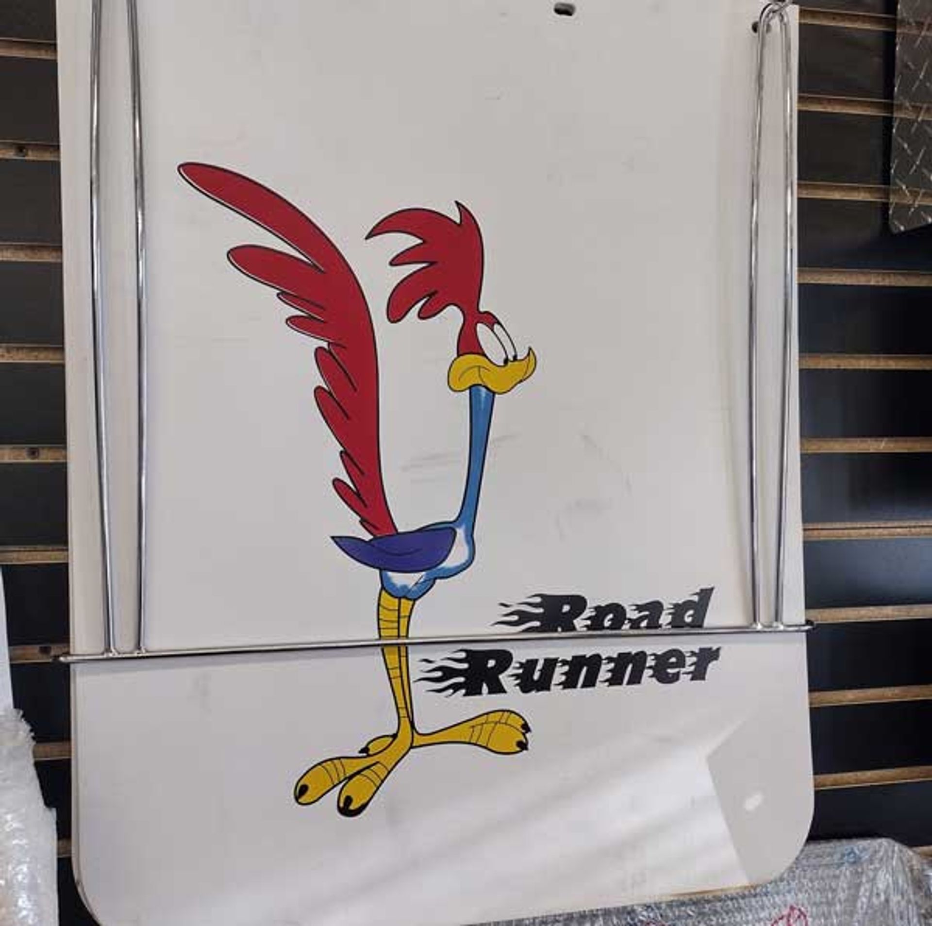 A road runner sticker is hanging on a wall