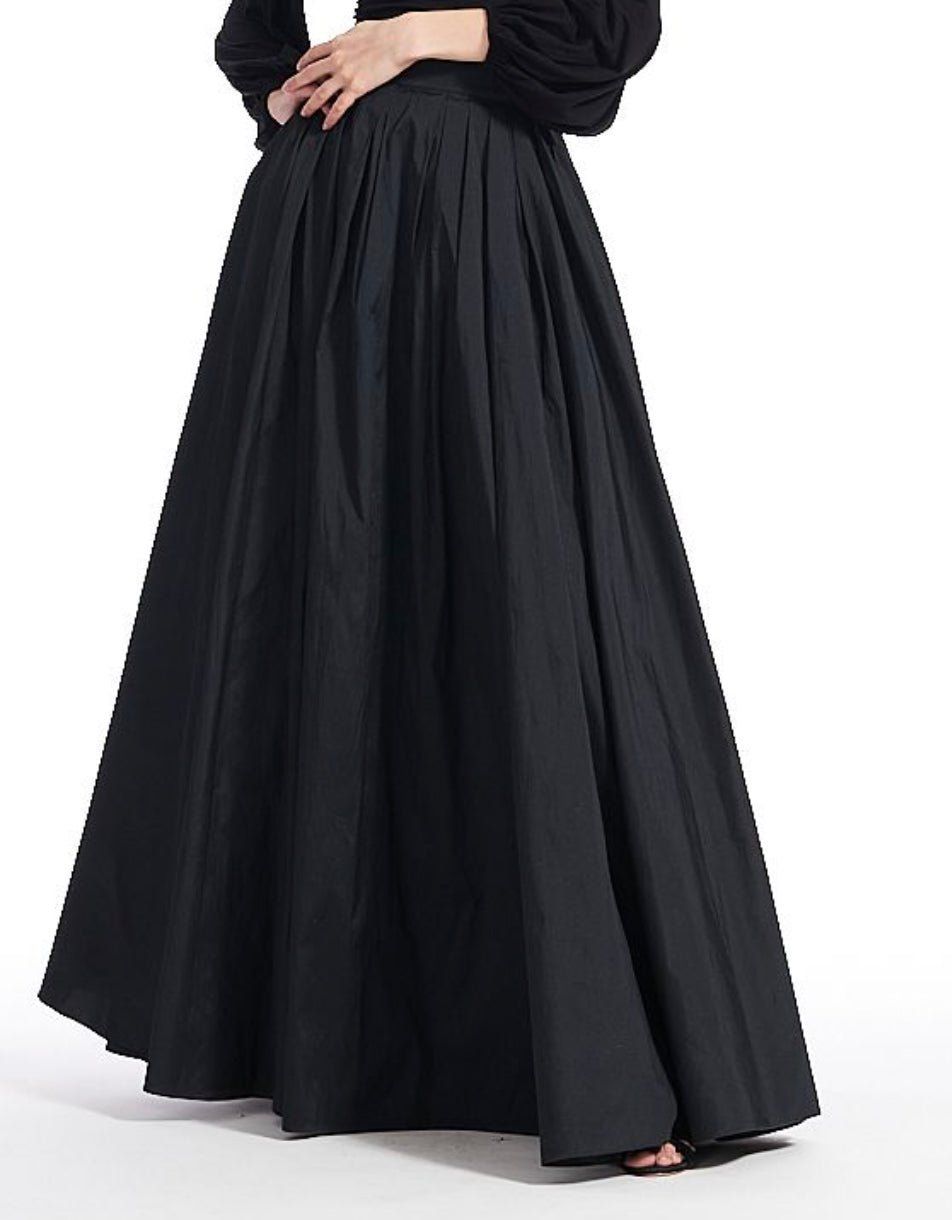 A woman is wearing a long black skirt and a black shirt.