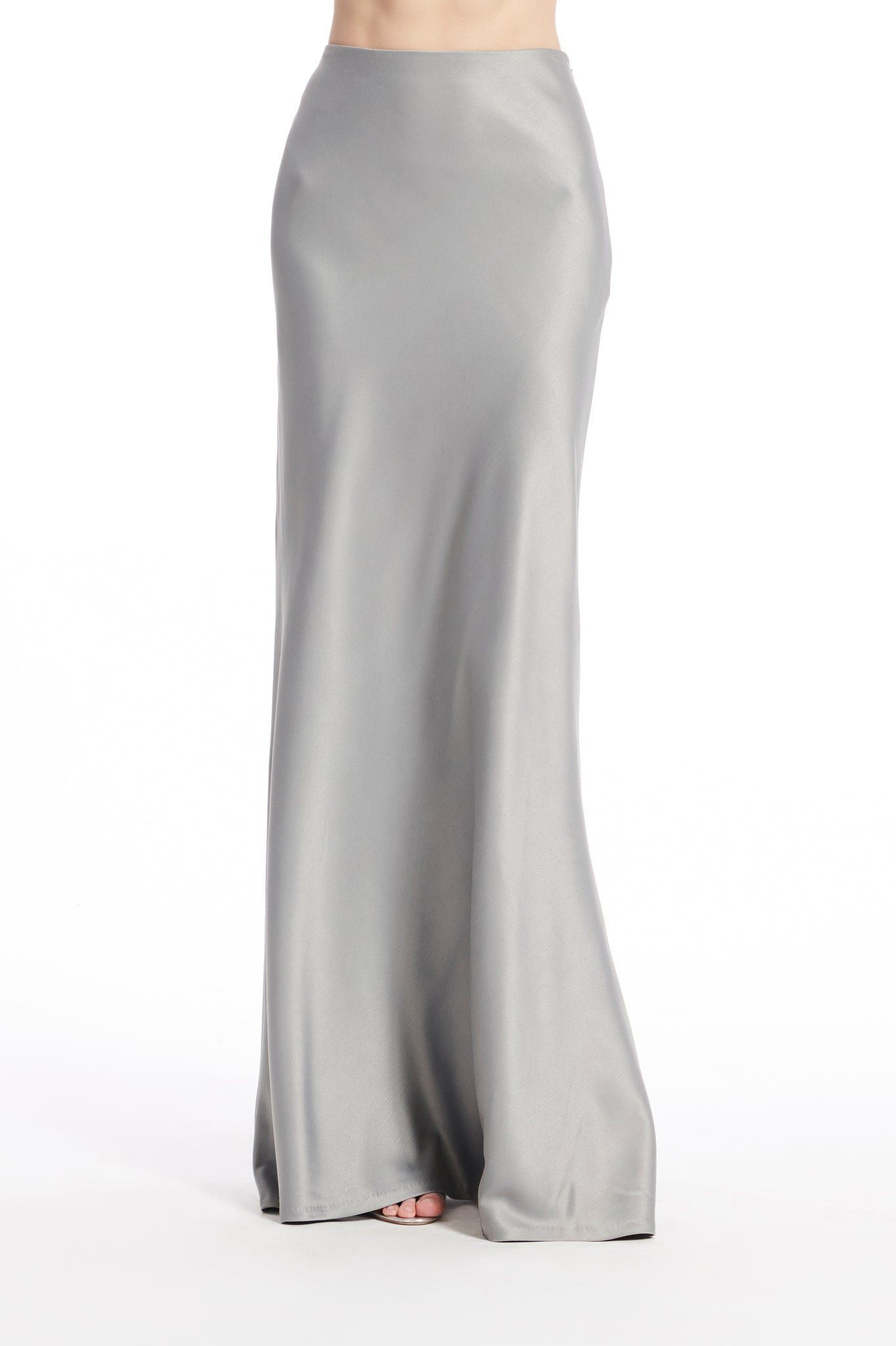 A woman is wearing a long gray satin skirt.