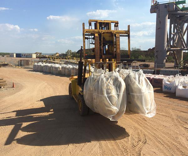 A Man Is Using A Trowel To Spread Concrete On A Sidewalk — Frontier Cement Supplies In East Arm, NT