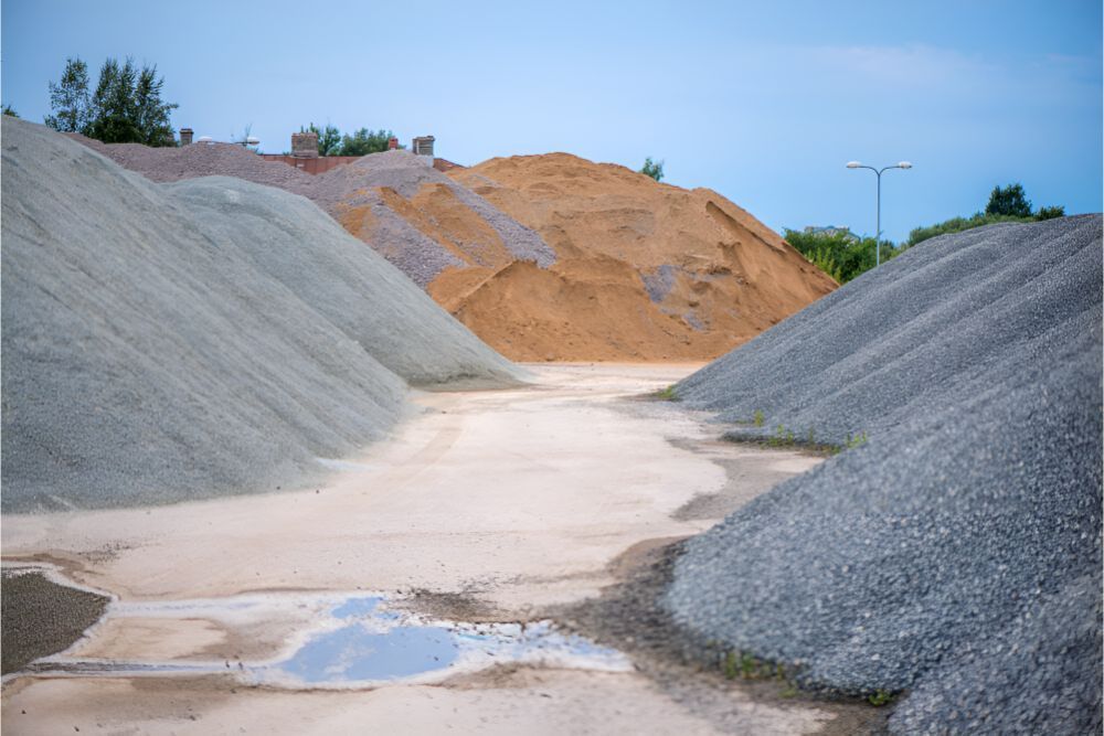 A Pile Of Gravel And Sand Is Sitting On Top Of A Dirt Road — Frontier Cement Supplies In Alice Springs, NT