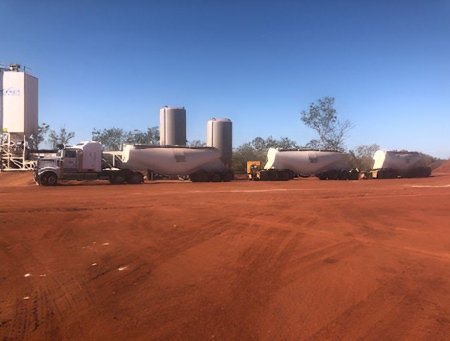 A Row Of Trucks Are Parked In A Dirt Lot — Frontier Cement Supplies In Kununurra, NT