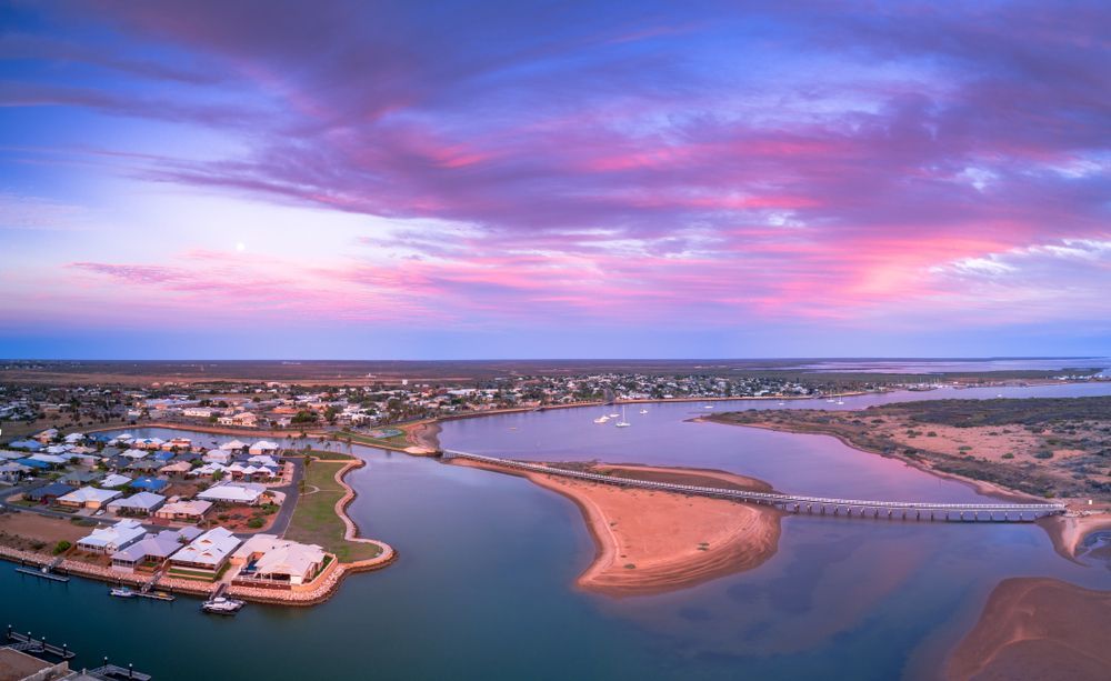 An Aerial View of a City and a Body of Water at Sunset — Frontier Cement Supplies In Carnarvon, NT