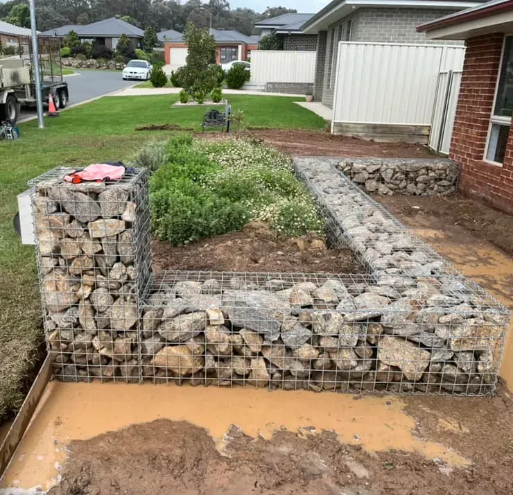 A Rock Cage Retaining Wall in A Front Garden — Robbo's Hire In Wodonga, VIC