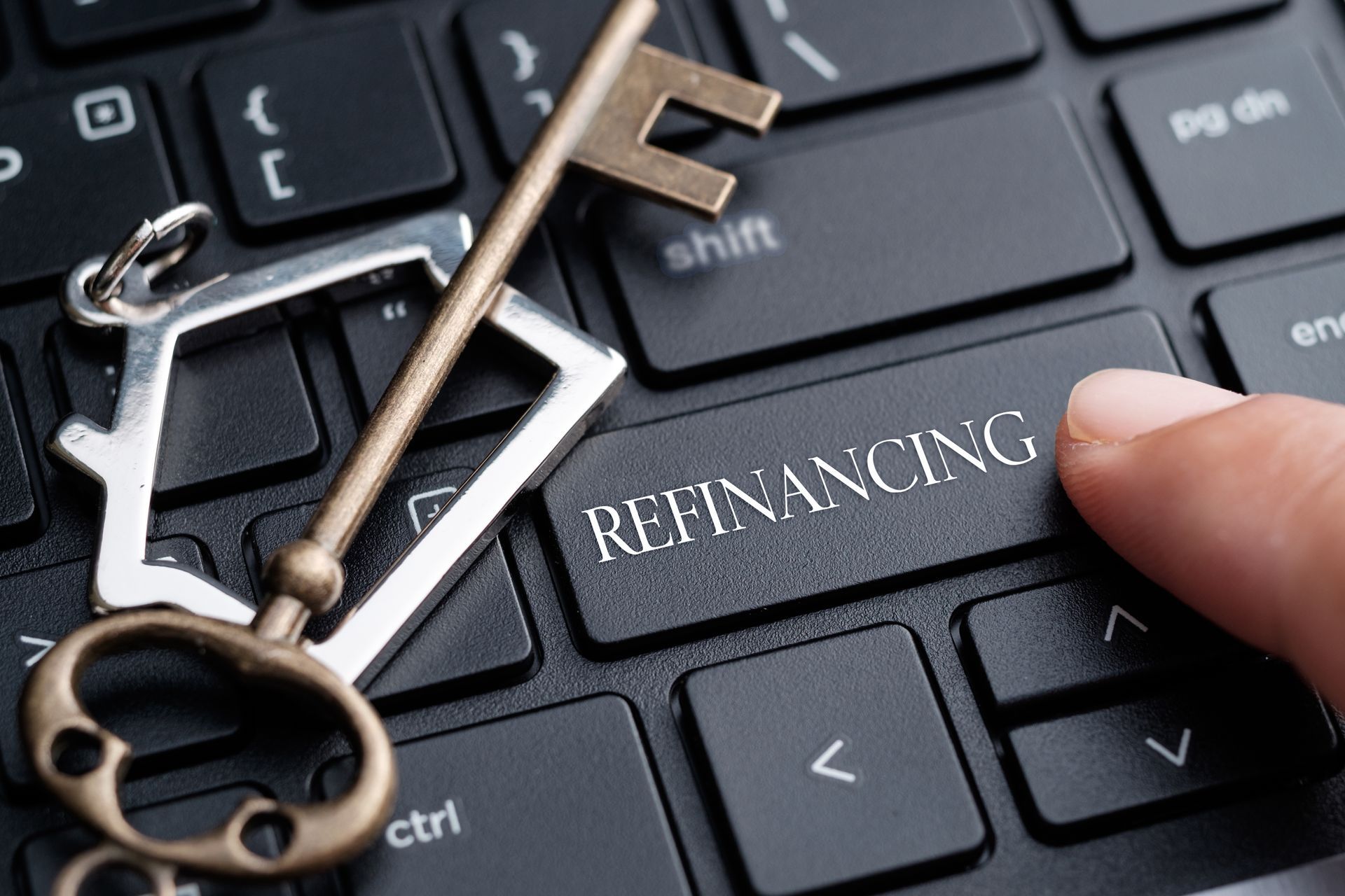 Closeup of finger on keyboard with word Refinancing