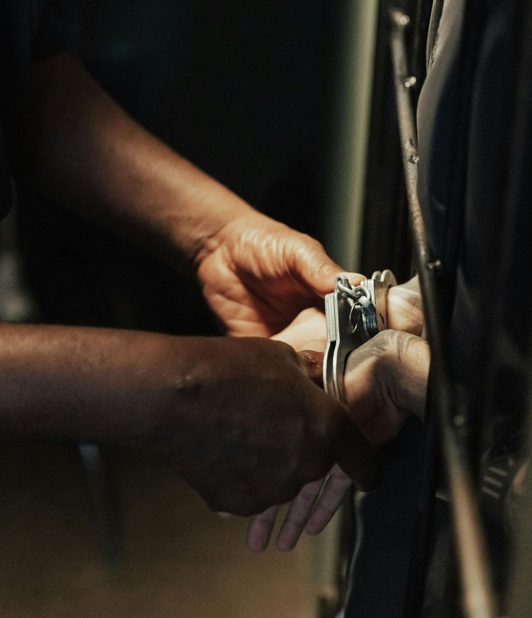 A person is being handcuffed by another person
